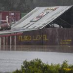 
              Flood waters surround an industrial property in Londonderry on the outskirts of Sydney, Australia, Monday, July 4, 2022. More than 30,000 residents of Sydney and its surrounds have been told to evacuate or prepare to abandon their homes on Monday as Australia's largest city braces for what could be its worst flooding in 18 months. (AP Photo/Mark Baker)
            