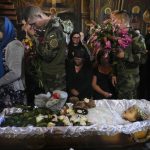 
              Relatives and friends pay their last respects to Liza, a 4-year-old girl killed by a Russian attack, during a mourning ceremony in an Orthodox church in Vinnytsia, Ukraine, Sunday, July 17, 2022. Wearing a blue denim jacket with flowers, Liza was among 23 people killed, including 2 boys aged 7 and 8, in Thursday's missile strike in Vinnytsia. Her mother, Iryna Dmytrieva, was among the scores injured. (AP Photo/Efrem Lukatsky)
            