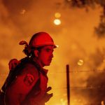 
              Firefighter Rafael Soto battles the Electra Fire burning in the Rich Gulch community of Calaveras County, Calif., on Tuesday, July 5, 2022. According to Amador County Sheriff Gary Redman, approximately 100 people sheltered at a Pacific Gas & Electric facility before being evacuated in the evening. (AP Photo/Noah Berger)
            