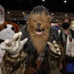 
              San Diego residents Sam Youth, as Port, from left, Mike Lever as Chewy Chewbacca, and Katie Lever, as Hans Solo, characters from "Star Wars," attends day one of Comic-Con International on Thursday, July 21, 2022, in San Diego. (Christy Radecic/Invision/AP)
            