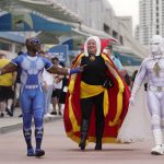 
              Jay Acey, left, dressed as A-Train from the television series "The Boys," Faeren Adams, center, dressed as Marvel superhero Doctor Strange, and Derek Shackleton, dressed as Marvel superhero Moon Knight, walk together outside Preview Night at the 2022 Comic-Con International at the San Diego Convention Center, Wednesday, July 20, 2022, in San Diego. (AP Photo/Chris Pizzello)
            