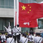 
              A flag raising ceremony is held at the Golden Bauhinia Square to mark the 25th anniversary of the former British colony's return to Chinese rule, in Hong Kong, Friday, July 1, 2022. (AP Photo/Magnum Chan, Pool)
            