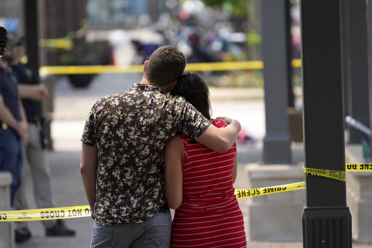 Brooke and Matt Strauss, who were married Sunday, look toward the scene of the mass shooting in dow...