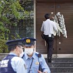 
              A worker brings a condolence flower to the residence of Japan's former Prime Minister Shinzo Abe who was assassinated Saturday, July 9, 2022, in Tokyo. The body of Japan’s former Prime Minister Shinzo Abe was returned to Tokyo on Saturday after he was fatally shot during a campaign speech in western Japan a day earlier.(Kyodo News via AP)
            