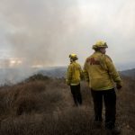 
              FILE - Firefighters watch as smoke rises from a wildfire in Fallbrook, northern San Diego County, Calif., Thursday, Dec. 24, 2020. Environmental groups have been arguing in California courts that developers are not fully considering the risks of wildfire and choked evacuation routes when they plan housing developments near fire-prone areas. (AP Photo/Ringo H.W. Chiu, File)
            