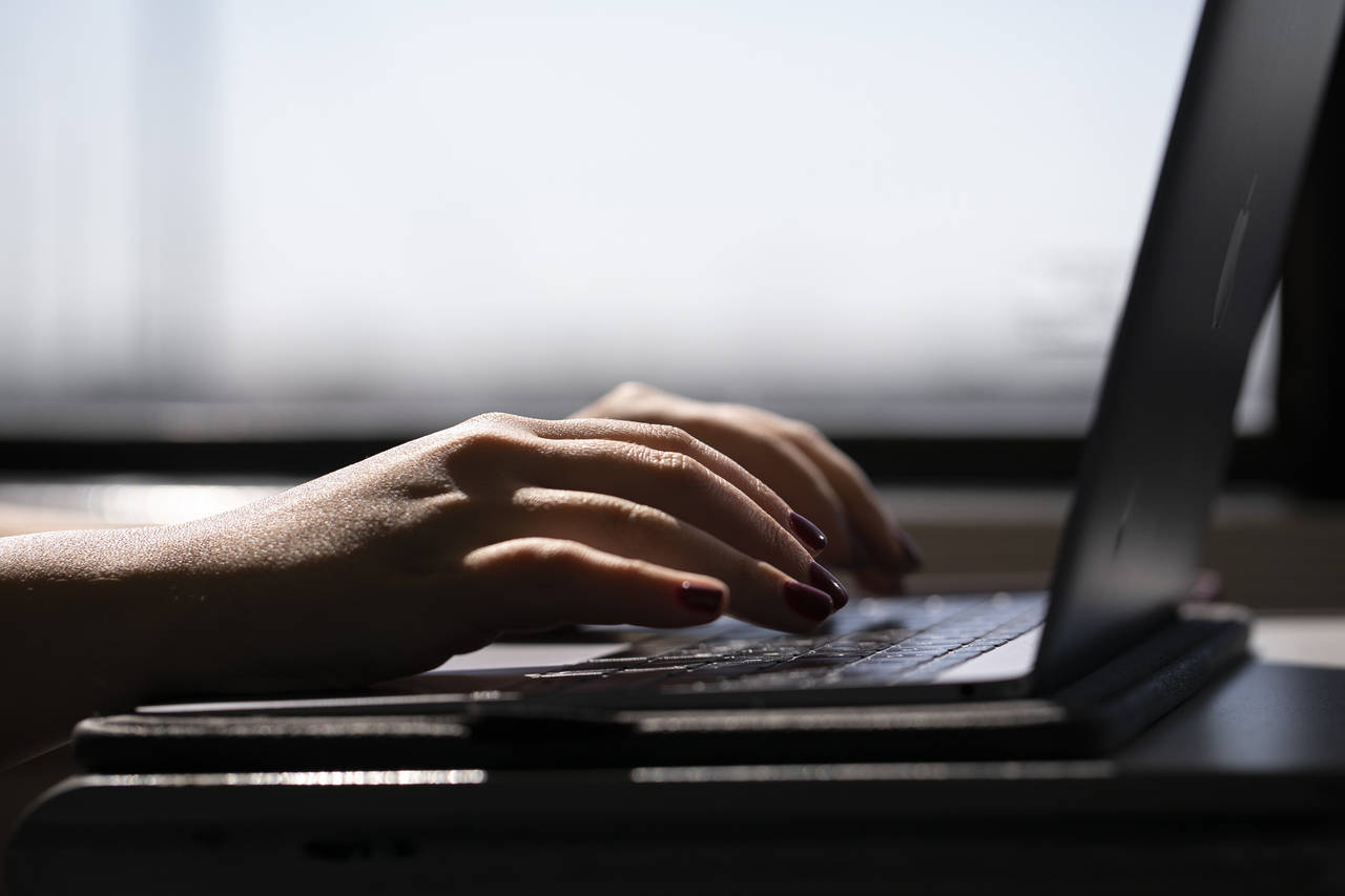 FILE - This May 18, 2021, photo shows a woman typing on a laptop on a train in New Jersey.  A movem...