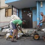 
              Viktor Lazar, right, cleans the street in front of his apartment in Saltivka district after Russian attacks in Kharkiv, Ukraine, Tuesday, July 5, 2022. (AP Photo/Evgeniy Maloletka)
            