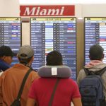 
              Travelers check their flights at Miami International Airport, Saturday, July 2, 2022, in Miami. The Fourth of July holiday weekend is jamming U.S. airports with the biggest crowds since the pandemic began in 2020. (AP Photo/Marta Lavandier)
            