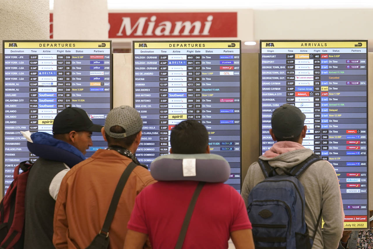 Travelers check their flights at Miami International Airport, Saturday, July 2, 2022, in Miami. The...