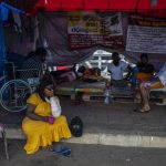 
              Protesters sit at their protest site in the morning in Colombo, Sri Lanka, Thursday, July 21, 2022. Sri Lanka's prime minister Ranil Wickremesinghe was elected president Wednesday by lawmakers who opted for a seasoned, veteran leader to lead the country out of economic collapse, despite widespread public opposition. (AP Photo/Rafiq Maqbool)
            