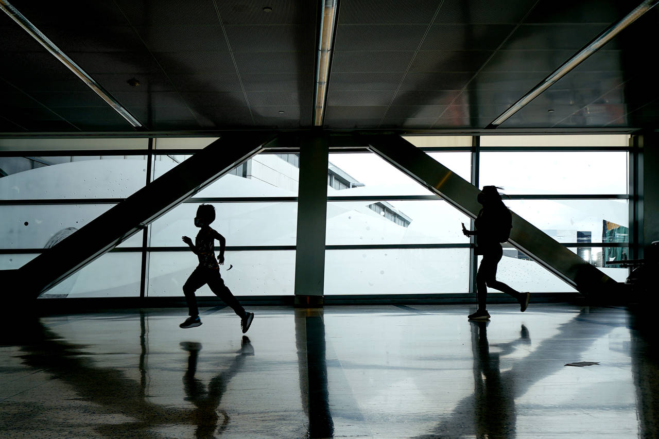 Travelers run to their gate at George Bush Intercontinental Airport, Friday, July 1, 2022, in Houst...