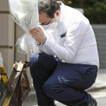 
              A man with a condolence flower prays toward the residence of Japan's former Prime Minister Shinzo Abe who was assassinated Saturday, July 9, 2022, in Tokyo. The body of Japan’s former Prime Minister Shinzo Abe was returned to Tokyo on Saturday after he was fatally shot during a campaign speech in western Japan a day earlier.(Kyodo News via AP)
            