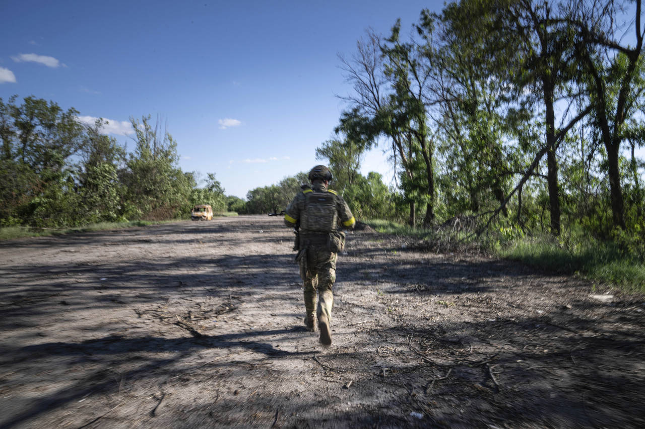 A Ukrainian serviceman changes his position at the frontline near Kharkiv, Ukraine, on Saturday, Ju...