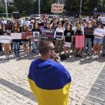 
              Protesters attend a rally in support of Ukrainian soldiers from the Azov Regiment who were captured by Russia in May after the fall of Mariupol, in Kyiv, Ukraine, Saturday, July 30, 2022. The rally comes a day after Russian and Ukrainian officials blamed each other for the deaths of dozens of Ukrainian prisoners of war in an attack Friday on a prison in a separatist-controlled area of eastern Ukraine. (AP Photo/David Goldman)
            