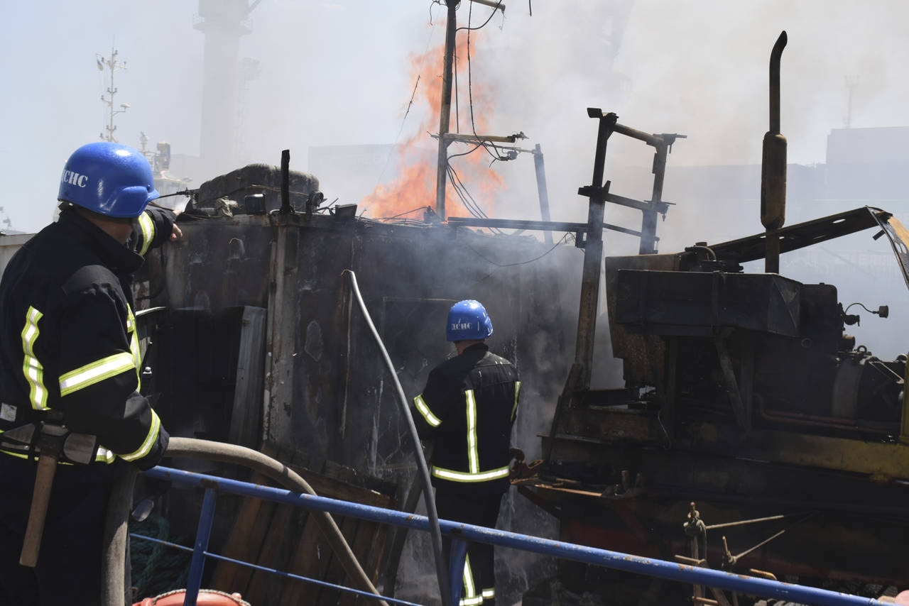In this photo provided by the Odesa City Hall Press Office, firefighters put out a fire in a port a...