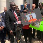 
              Attorney Benjamin Crump, foreground left, and Doreen Coleman, mother of Randy Cox, hold a poster of Cox, outside a courthouse in New Haven, Conn., Friday, July 8, 2022. Cox, who was being transported in a police van without seatbelts, was paralyzed when the van braked suddenly. His family asked federal authorities Friday to file civil rights charges against the officers involved. (Ben Lambert/New Haven Register via AP)
            