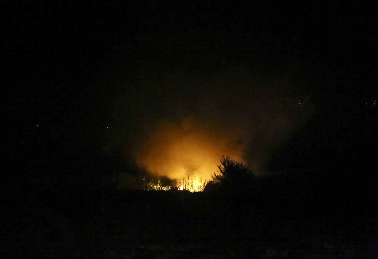 Flames are seen at the site of a plane crash, a few miles away from the city of Kavala, in northern...
