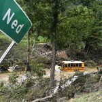
              A Perry County school bus lies destroyed after being caught up in the floodwaters of Lost Creek in Ned, Ky., Friday, July 29, 2022. (AP Photo/Timothy D. Easley)
            