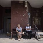 
              Pavel Govoryhov, 84, and Tatiana Koneva, 75, residents of Saltivka district, sit on a bench in front of their apartment house in Kharkiv, Ukraine, Tuesday, July 5, 2022. (AP Photo/Evgeniy Maloletka)
            