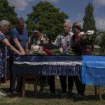 
              The mother of 40-year-old Volodymyr Miroshnychenko who was killed on the frontlines of Marinka, mourns during his funeral procession at a cemetery in Pokrovsk, eastern Ukraine, Friday, July 15, 2022. (AP Photo/Nariman El-Mofty)
            