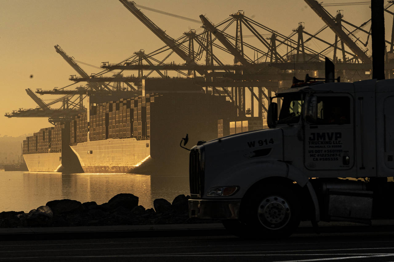 FILE - A truck arrives to pick up a shipping container near vessels moored at Maersk APM Terminals ...