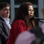 Sen. Tammy Duckworth, right, D-Ill., speaks as Illinois Gov. J.B. Pritzker listens at a news conference at Highland Park Fire Department station 33., after a mass shooting at the Highland Park Fourth of July parade in downtown Highland Park, a Chicago suburb, on Monday, July 4, 2022. (AP Photo/Nam Y. Huh)
