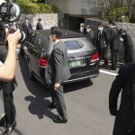
              A car which is believed to carry the body of former Prime Minister Shinzo Abe, arrives at his home Saturday, July 9, 2022, in Tokyo. Former Prime Minister Shinzo Abe was assassinated on a street in western Japan by a gunman who opened fire on him from behind as he delivered a campaign speech Friday. (AP Photo/Eugene Hoshiko)
            