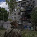 
              A Ukrainian soldier looks at five-story residential building damaged from a rocket attack on a residential area, in Kramatorsk, eastern Ukraine, Tuesday, July 19, 2022. (AP Photo/Nariman El-Mofty)
            