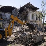 
              An excavator clear the rubble of military registration office destroyed by Russian attack in Kharkiv, Ukraine, Wednesday, July 6, 2022. (AP Photo/Evgeniy Maloletka)
            