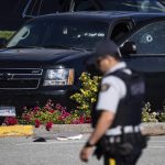 
              A police officer walks near a windshield and passenger window of an RCMP vehicle with bullet holes at the scene of a shooting in Langley, British Columbia, Monday, July 25, 2022. Canadian police reported multiple shootings of homeless people Monday in a Vancouver suburb and said a suspect was in custody. (Darryl Dyck/The Canadian Press via AP)
            