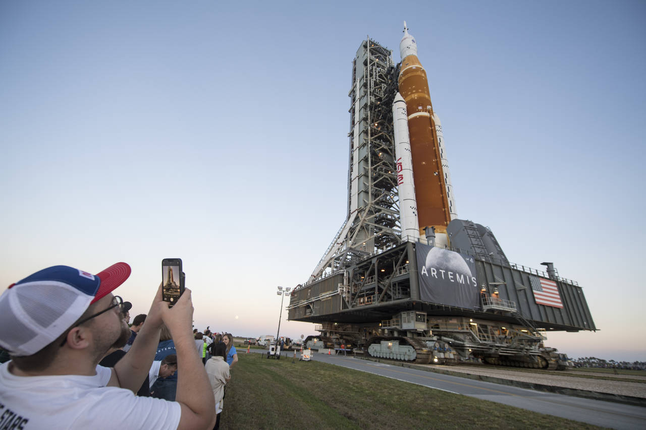 FILE - Invited guests and NASA employees take photos as NASA's Space Launch System (SLS) rocket wit...