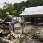 Volunteers from the local Mennonite community remove debris from flood damaged property at Ogden Hollar in Hindman, Ky., Saturday, July 30, 2022. (AP Photo/Timothy D. Easley)