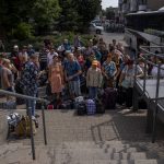 
              Internally displaced people wait to board a train heading to Dnipro, at the Pokrovsk train station, Donetsk region, eastern Ukraine, Friday, July 8, 2022. (AP Photo/Nariman El-Mofty)
            
