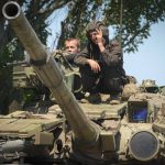 
              FILE - A Ukrainian soldier flashes the victory sign atop a tank in Donetsk region, Ukraine, June 20, 2022. Ukraine has asked the West to provide it with armor to help replenish its heavy battlefield losses. The country has reportedly received about 300 Soviet-built T-72 tanks from Poland and the Czech Republic and already used them in combat. (AP Photo/Efrem Lukatsky, File)
            