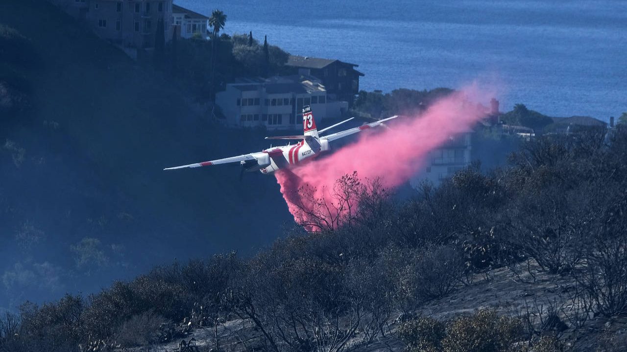 FILE - A plane drops retardant on a wildfire near homes Thursday, Feb. 10, 2022, in Laguna Beach, C...