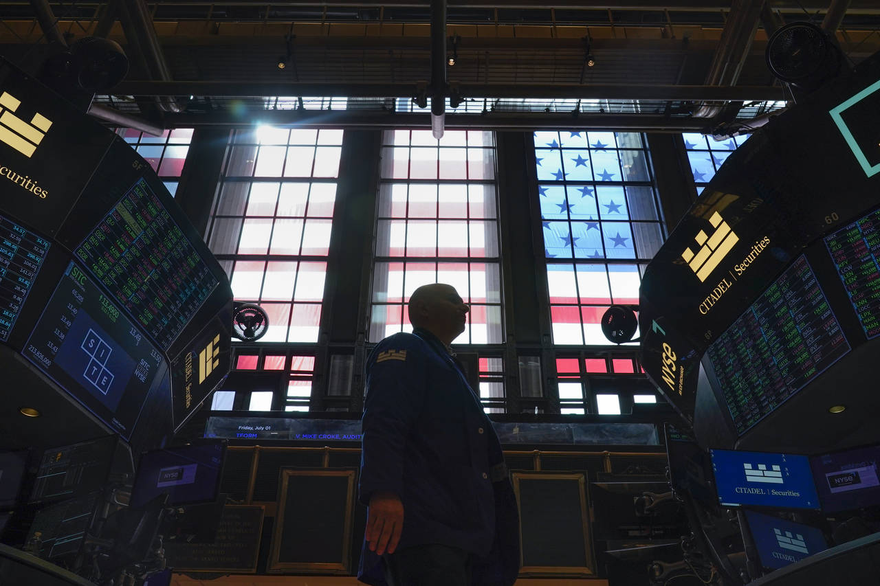 FILE - Traders work on the floor at the New York Stock Exchange in New York, July 1, 2022. This yea...