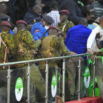 
              Opposition supporters of Raila Odinga scuffle with riot police at the Centre in Bomas, Nairobi, Kenya, Monday, Aug. 15, 2022.. Kenya's election commission announced Monday that William Ruto, has won with 50.49 percent of the vote, and called the vote "credible, fair and peaceful". (AP Photo/ Sayyid Abdul Azim)
            