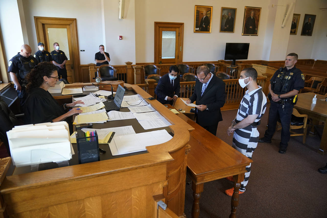 Hadi Matar, 24, second from right, listens as his public defense attorney Nathaniel Barone, center,...