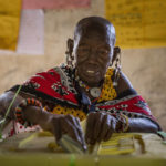 
              A Maasai woman casts her vote at a polling station in Esonorua Primary School, in Kajiado County, Kenya Tuesday, Aug. 9, 2022. Polls opened Tuesday in Kenya's unusual presidential election, where a longtime opposition leader who is backed by the outgoing president faces the deputy president who styles himself as the outsider. (AP Photo/Ben Curtis)
            