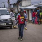 
              A boy carries a baby on his back on a street in the Kibera area of Nairobi, Kenya Friday, Aug. 12, 2022. Vote-tallying in Kenya's close presidential election isn't moving fast enough, the electoral commission chair said Friday. (AP Photo/Ben Curtis)
            