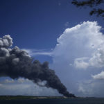 
              A huge plume of smoke rises from the Matanzas Supertanker Base, as firefighters work to quell a blaze which began during a thunderstorm the night before, in Matazanas, Cuba, Saturday, Aug. 6, 2022. Cuban authorities say lightning struck a crude oil storage tank at the base, causing a fire that led to four explosions which injured more than 50 people. (AP Photo/Ramon Espinosa)
            