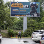 
              A person walks past a billboard reading " Sign up for a volunteer team" encouraging Russians to sign up for the Tiger volunteer battalion, at the far-eastern Primorye region in a street of Vladivostok, Russia, Thursday, Aug. 11, 2022. Colorful billboards and ads on public transport in different Russian regions state that "heroes are wanted" and urge Russian men to join the professional army ranks. (AP Photo)
            