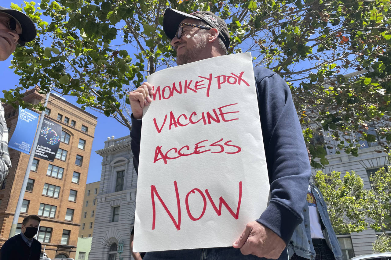 FILE - A man holds a sign urging increased access to the monkeypox vaccine during a protest in San ...