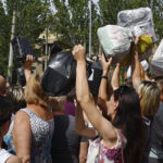 
              Local residents, many of whom fled the war, gather to hand out donated items such as medicines, clothes, and personal belongings to their relatives on the territories occupied by Russia, in Zaporizhzhia, Ukraine, Sunday, Aug. 14, 2022. Volunteers transport these items across the frontline and distribute them to addresses at their own risk. (AP Photo/Andriy Andriyenko)
            