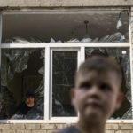 
              A worker cleans up inside as Tikhon Pavlov, 11, walks past the Kramatorsk College of Technologies and Design, where he used to take karate lessons, after an early morning rocket attack in Kramatorsk, Donetsk region, eastern Ukraine, Friday, Aug. 19, 2022. Russia continued to shell towns and villages in Ukraine's embattled eastern Donetsk region, according to regional authorities, where Russian forces are pushing to overtake areas still held by Ukraine. (AP Photo/David Goldman)
            
