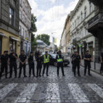 
              Police officers block a street where visiting leaders will travel to meet Ukrainian President Volodymyr Zelenskyy in downtown Lviv, Ukraine, on Thursday, Aug, 18, 2022. The Ukrainian leader is due to meet United Nations Secretary General Antonio Guterres and Turkish President Recep Tayyip Erdogan in the city which is near Ukraine's border with Poland. The protesters held up banners in Ukrainian and English, several reading "Russia is a terrorist state." Police and army officers fanned out across the city, condoning off parts of the center as the visiting leaders were driven through its cobblestone streets. (AP Photo/Evgeniy Maloletka)
            