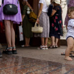 
              A baby is helped by its mother to stand during a service outside St. Michael's Ukrainian Orthodox Church of the Moscow Patriarchate on Savior of the Honey Feast Day in Pokrovsk, Donetsk region, eastern Ukraine, Sunday, Aug. 14, 2022. (AP Photo/David Goldman)
            