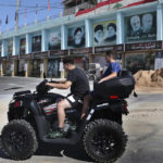 
              Lebanese boys ride their ATV in front of posters that show from left, the late revolutionary founder Ayatollah Khomeini, the Supreme Leader Ayatollah Ali Khamenei, Hezbollah leader Sayyed Hassan Nasrallah, the late Iranian Revolutionary Guard Gen. Qassem Soleimani, the late Iraq's Popular Mobilization forces commander Abu Mahdi al-Muhandis and the late Hezbollah military commander Imad Mughniyeh, in the Lebanese-Israeli border village of Yaroun, south Lebanon, Saturday, Aug. 13, 2022, where the parents of Hadi Matar emigrated from. On Friday, Matar, 24, born in Fairview, N.J., attacked author Salman Rushdie during a lecture in New York. His birth was a decade after "The Satanic Verses" was first published. (AP Photo/Mohammed Zaatari)
            