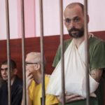 
              From left, British John Harding, Croatian Vjekoslav Prebeg, Swedish Mathias Gustafsson, and British Andrew Hill are seen behind bars in a courtroom in Donetsk, city in eastern Ukraine controlled by separatist authorities of the unrecognized Donetsk People's Republic, Monday, Aug. 15, 2022. The five foreign nationals who fought alongside Ukrainian forces were captured in in the eastern city of Mariupol and are standing trial on the charges of being mercenaries. (AP Photo)
            