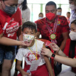 
              CORRECTS LOCATION A boy receives a COVID-19 Pfizer vaccine during the opening of classes at the San Juan Elementary School in metro Manila, Philippines on Monday, Aug. 22, 2022. Millions of students wearing face masks streamed back to grade and high schools across the Philippines Monday in their first in-person classes after two years of coronavirus lockdowns that are feared to have worsened one of the world's most alarming illiteracy rates among children. (AP Photo/Aaron Favila)
            